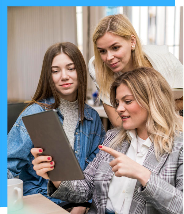 3 women looking at tablet